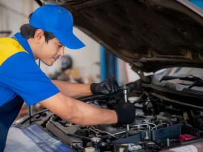 Asian man in car service, repair, maintenance and people concept, happy smiling auto mechanic man or smith with clipboard at workshop